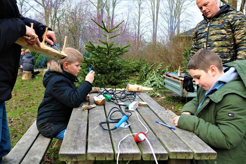 Gustav og Oskar brænder tekst i deres snittearbejde.